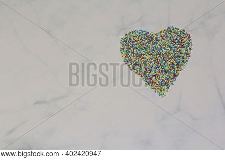 Sprinkles Arranged In A Heart Shape On A White Grey Marble Rustic Background. Valentines Day, Greeti