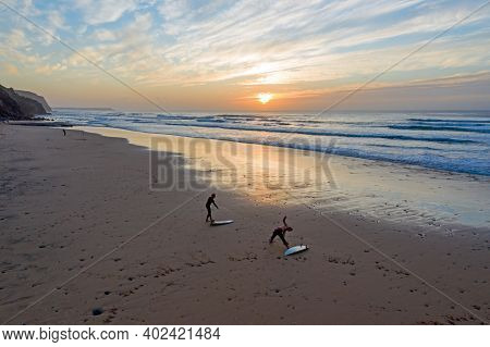 Aerial from two surfers at Vale Figueiras Beach in Portugal at sunset
