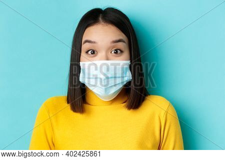 Covid-19, Social Distancing And Pandemic Concept. Close Up Of Surprised Asian Woman In Medical Mask,