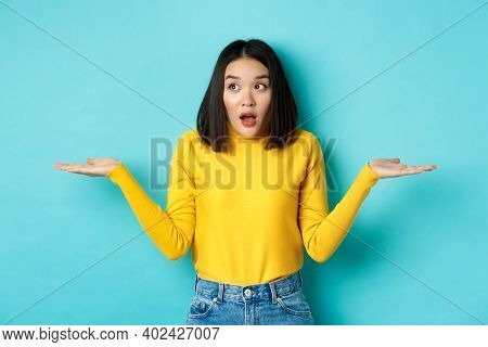 Confused And Shocked Asian Woman Dont Understand, Shrugging With Spread Hands, Gasping And Looking L