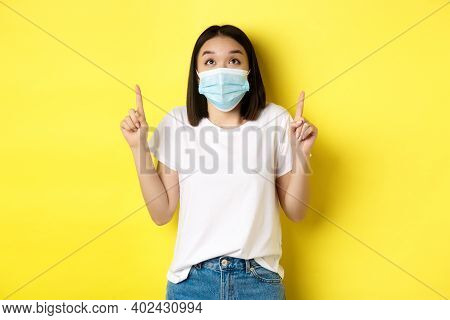 Covid-19, Pandemic And Social Distancing Concept. Young Asian Woman In White T-shirt And Medical Mas