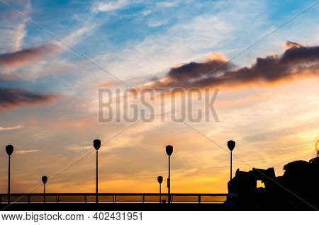 Dark Silhouettes Of Peopl That Are Trying To Make A Photo Of Sunset With Their Smartphones