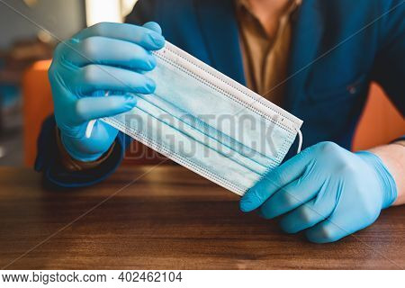 Businessman Hands In Protective Gloves Hold A Medical Mask, Close-up