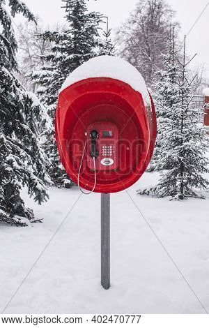A Red Old Pay Phone In A Winter Park After A Heavy Snow Fall. Vertical Photo, Front View.
