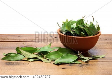 Bowl Of Lemon Myrtle Leaves On Wooden Background