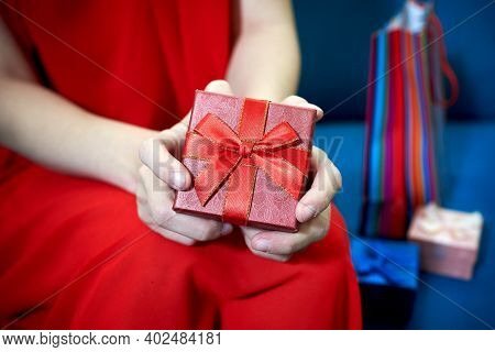 Female Hands Holding Red Gift Box With A Bow.