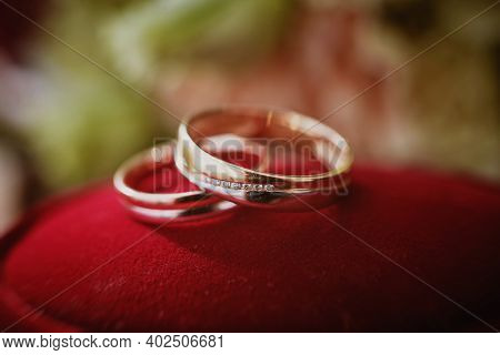 Close Up View Of Wedding Rings On A Red Velvet Box.