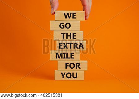 Go The Extra Mile Symbol. Wooden Blocks With Words 'we Go The Extra Mile For You'. Male Hand. Beauti
