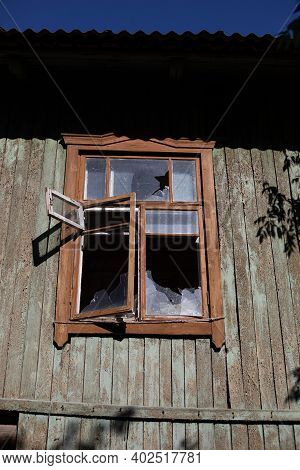 Broken Window Of An Abandoned House, With Naked Walls No Plasterwork .