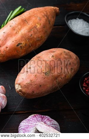 Sweet Potato Or Batat With Herbs On Old Wooden Table.