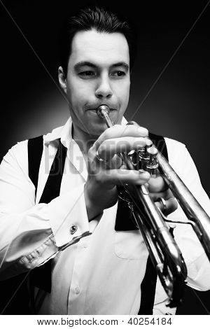 Retrato de um músico tocando a trombeta. Fundo preto.