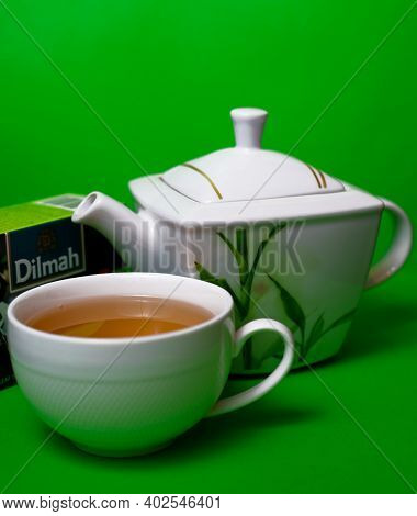 Teapot And Cup Of Dilmah Green Leaf Tea On A Green Background. 06.01.2021. Warsaw, Poland