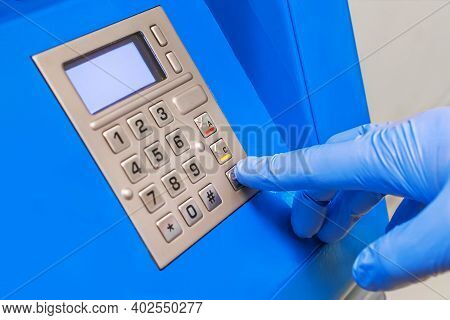 A Man's Hand In Protective Medical Gloves Dials A Pincode At The Terminal For Issuing Money, Close-u