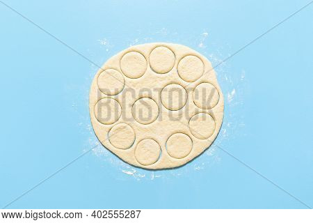 Cooking Doughnuts, Raw Donut Dough Cut In Round Shapes, On Blue Background. Flat Lay With Uncooked Y