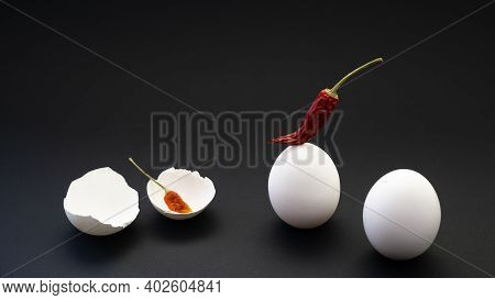 Chili Peppers And Fresh Chicken Eggs With A Broken Hollow Shell On The Atomic Surface. Beginning A D