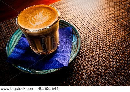 Flat White Coffee Is Served On Saucer Over The Table With Bamboo Mat, Copyspace
