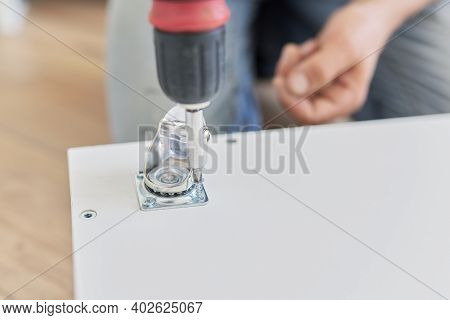 Furniture Assembly Parts, Furniture Wheels Close-up. Worker Hands Assembling Furniture Using Profess