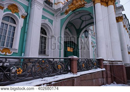 Hermitage Museum or Winter palace in Saint-Petersburg. Burning windows on a twilight day. One of the entrances.