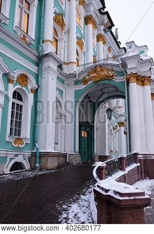 Hermitage Museum or Winter palace in Saint-Petersburg. Burning windows on a twilight day. One of the entrances.
