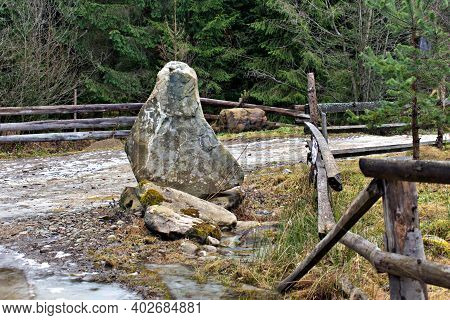 Huge Natural Stone Near Wooden Fence On Road In Countryside