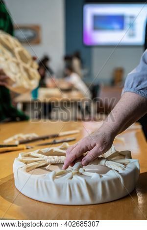 Selective Focus. Close Up Of Elderly Hands Touching A Native Drum On A Work Table During A Workshop.