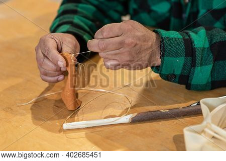 Close Up Of Mans Hands Sewing A Piece Of Leather To Create The Soft Head Of A Wooden Drum Stick, Dur