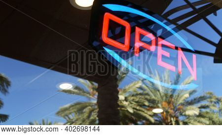 Open Neon Sign Glowing In The Dark. Vivid Retro Styled Text At Entrance On Glass Window. Colorful El