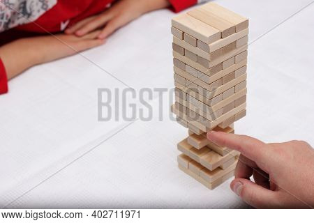 Vladivostok, Russia-01 January, 2021: Close Up Hand Holding Blocks Wood Game -jenga- On White Backgr