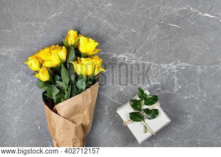 Yellow Roses In Craft Paper And Trendy Gift Box In Recycled Paper On Gray Background. Natural Aestet
