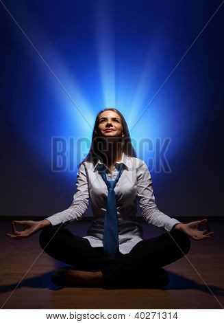 Mladý obchodní žena sedí v asana lotus a meditací
