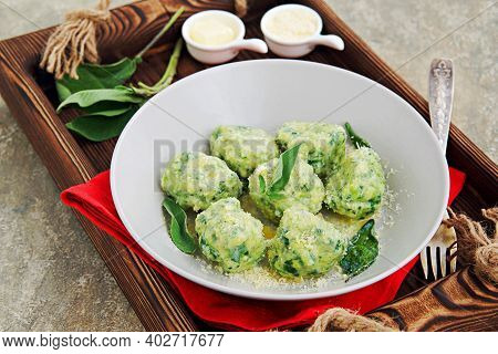 Ricotta And Spinach Gnocchi Or Dumplings With Parmesan Cheese And Sage Butter In A Gray Plate On A C