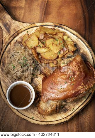 Schweinshaxe Traditional German Pork Knuckle With Sauerkraut And Potatoes Bavarian Meal On Rustic Wo