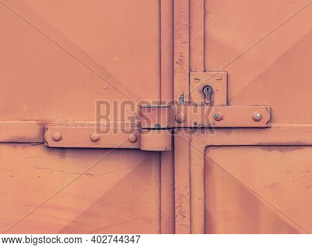 Lock Case On Latch And Lock Insert. Industrial Red Sheet Metal Doors Locked Against Theft.