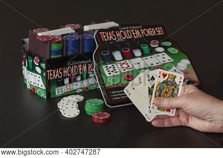 Texas Hold 'em Pokergame In A Metal Box For Leisure Poker Playing At Home. Hand Holding Cards Showin