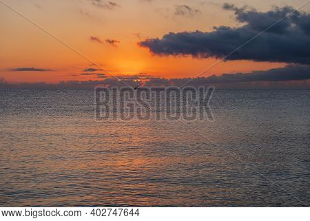 Sunrise With The Red Orange Sun Raising Up From The Sea With Dark Clouds At Beach Spiaggia Di Santa 