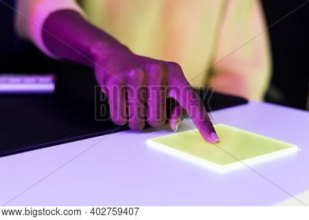 Index finger pressing on yellow transparent plate smart technology