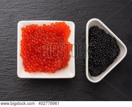 Grainy Caviar Of Paddlefish Fish In A White Ceramic Plate And Red Chum Salmon Caviar In A White Cera