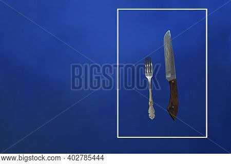 Fork And Knife In A Frame On A Blue Background. Road Sign Concept.