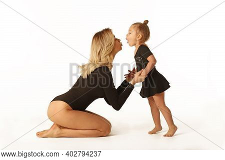 Cute Baby Girl And Mum In Black Bodies Having Fun Full Body Studio Portrait
