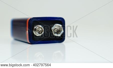 One Blue Used Pp3 Battery On A White Background With Reflection. Main Battery For Personal Power Sup