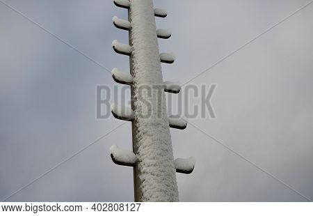 Power Lines Frozen By A Large Layer Of Ice In The Shape Of A Cylinder With Icicles. Icing Loads The 