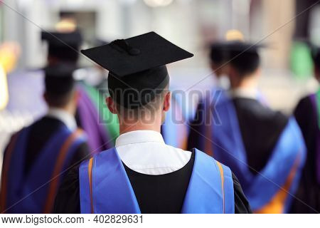 Graduates at university graduation  ceremony wearing mortarboard and gown