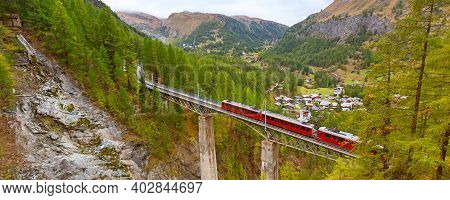 Zermatt, Switzerland. Gornergrat Red Tourist Train On The Bridge In Swiss Alps Banner Panorama