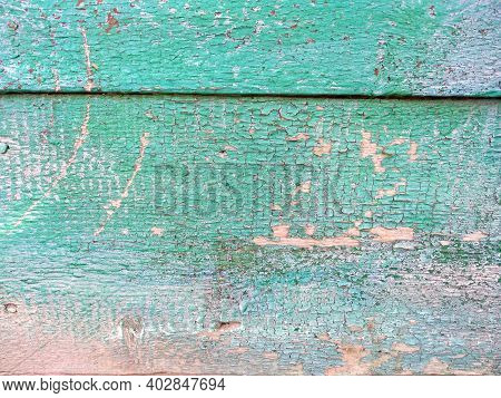 Close-up Old Green Cracked Paint On Wood. The Texture Of The Old Emerald Paint With Cracks. Dried In