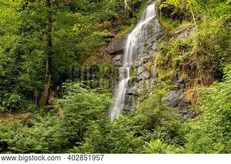 Long Exposure Of The Waterfall Flowing Over The Cliff At Canonteign Falls In Dartmoor