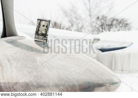 A Dollar, A Bundle Of Rolled-up Dollars Is On The Prop Of A Private Plane.