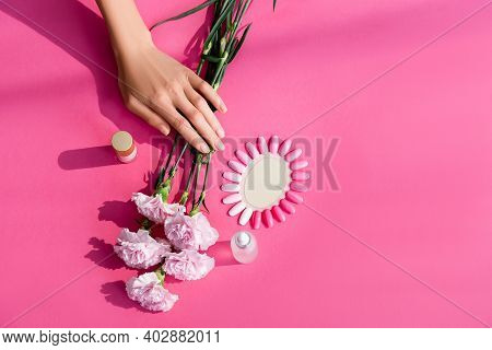 Top View Of Female Hands Near Bottles With Nail Varnish And Cuticle Remover, Carnation Flowers And P