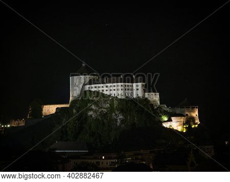 Aerial Panorama Of Illuminated Medieval Castle Festung Kufstein Fortress At Night In Town Tyrol Aust