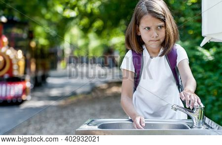 Girl Washing Her Hands At The Park. Baby Try To Turn Off Water Faucet. A Child's Hand Turning Off Th