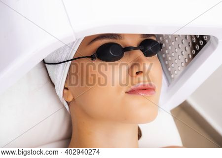 Treatment Of The Skin With Ultraviolet Light. The Girl Lies In The Beautician's Office For The Photo